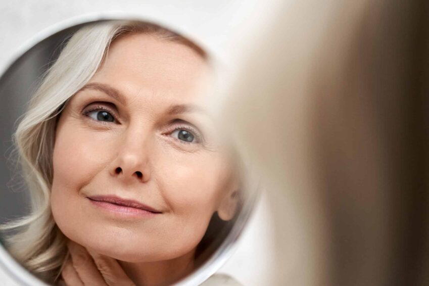 Woman looking at her skin in the mirror