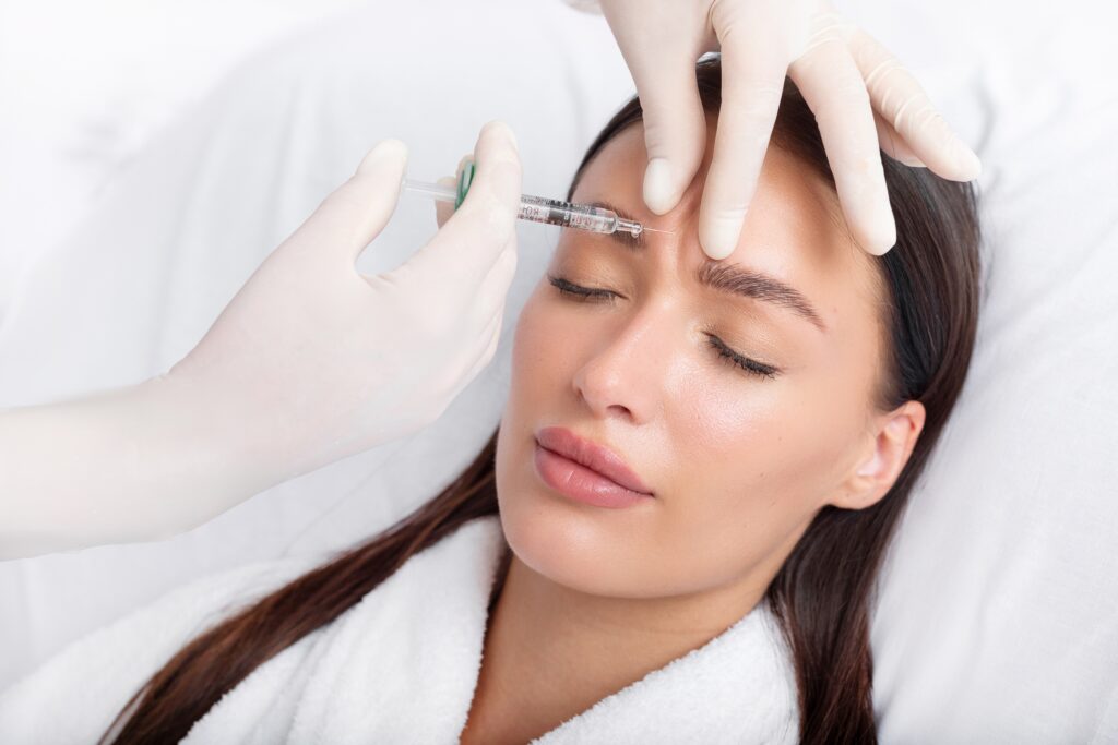 Woman getting filler injected into her forehead