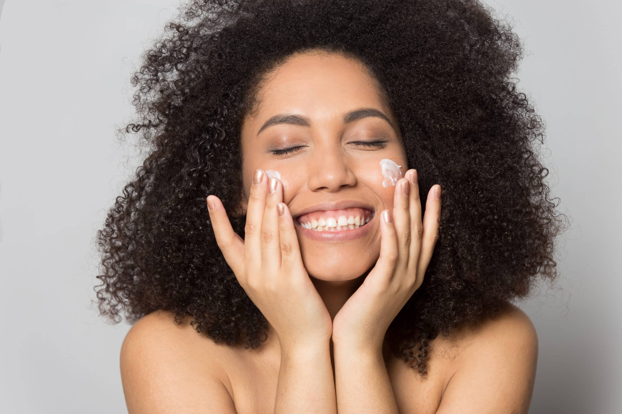 Woman smiling applying skin care